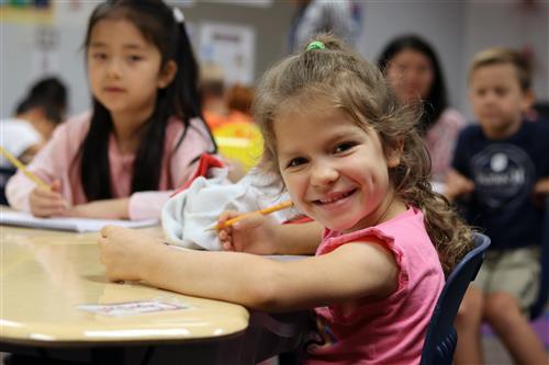 A imagine of a elementary school student smiling at the camera