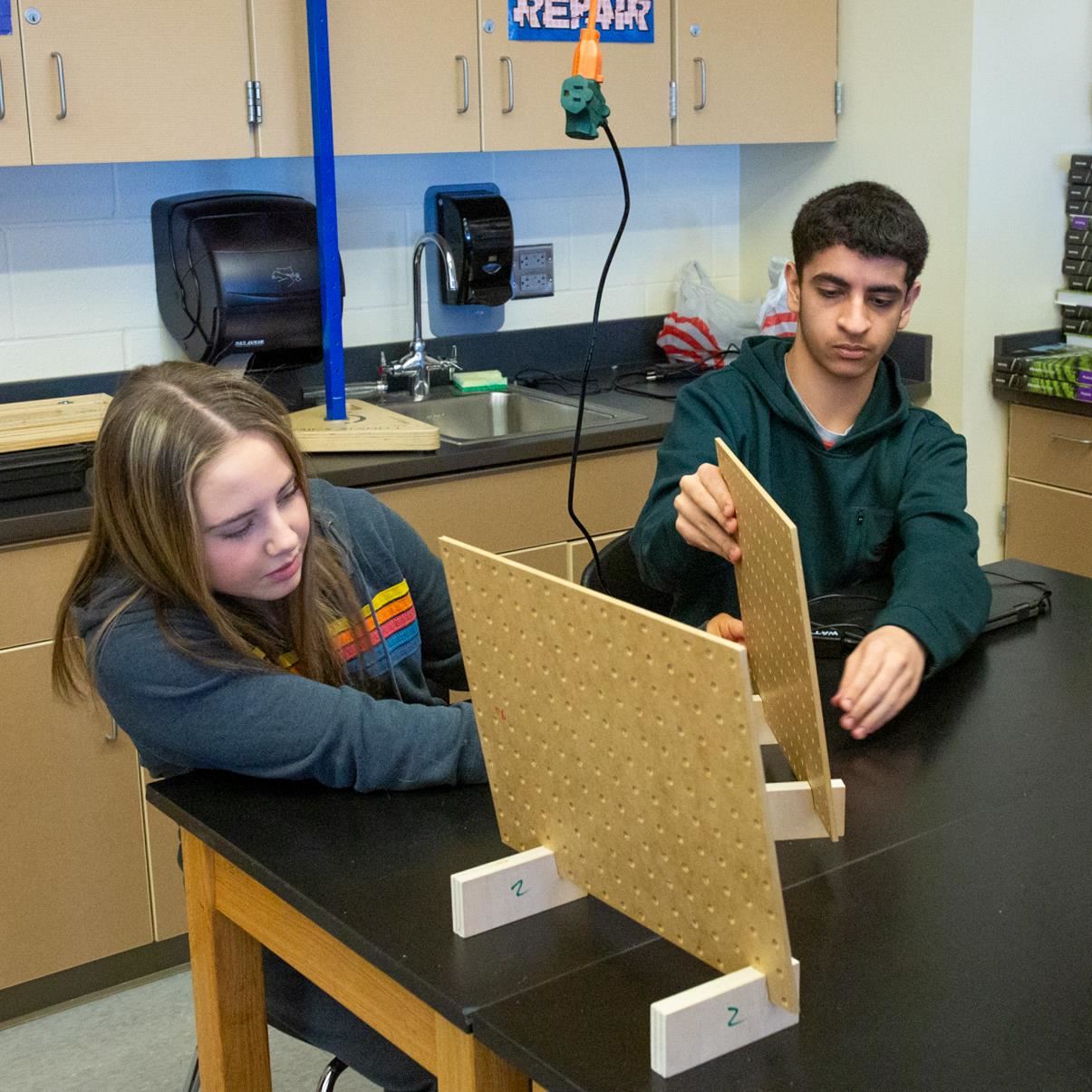 Two students collaborate on a hands-on project, representing our student-centered core value.